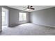 Spacious bedroom with soft carpet, ceiling fan, and a bright window at 1365 Waxwing Ave, Brighton, CO 80601