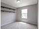 Cozy bedroom with neutral carpeting, gray walls, a built-in floating shelf, and natural light at 1365 Waxwing Ave, Brighton, CO 80601