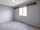 Neutral bedroom featuring gray walls, plush carpeting, a floating shelf, and a bright window at 1365 Waxwing Ave, Brighton, CO 80601