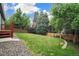 Lush backyard with mature trees, a well-maintained lawn, and stone landscaping at 517 Sylvestor Trl, Highlands Ranch, CO 80129
