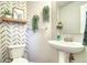 Charming powder room featuring patterned wallpaper, pedestal sink and a decorative mirror at 517 Sylvestor Trl, Highlands Ranch, CO 80129