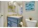 Cozy bathroom with a blue vanity, decorative mirror, and artistic wall decor at 517 Sylvestor Trl, Highlands Ranch, CO 80129