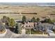 Aerial view showcases the house nestled in mature trees with sprawling field and lake views at 5106 S Kenton Way, Greenwood Village, CO 80111