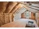 Unfinished attic space with exposed insulation and door to the exterior at 5106 S Kenton Way, Greenwood Village, CO 80111
