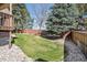 Landscaped backyard with a green lawn, rock border, brick fence, and trees at 5106 S Kenton Way, Greenwood Village, CO 80111