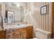 Bathroom featuring a light countertop, wood cabinets, and a large mirror at 5106 S Kenton Way, Greenwood Village, CO 80111