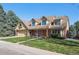 Charming brick home featuring a three car garage, well-manicured lawn, and a delightful covered front porch at 5106 S Kenton Way, Greenwood Village, CO 80111