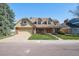 A charming house with a well-manicured lawn, a brick facade, and a spacious driveway at 5106 S Kenton Way, Greenwood Village, CO 80111