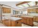 Spacious kitchen featuring light wood cabinets, tile countertops, island, and a large window with tree views at 5106 S Kenton Way, Greenwood Village, CO 80111