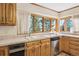 Kitchen features stainless steel dishwasher, white double sink, wood cabinets, and a large window with view at 5106 S Kenton Way, Greenwood Village, CO 80111