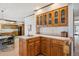 Dry bar area featuring light wood cabinets, tile countertops, and an open floor plan at 5106 S Kenton Way, Greenwood Village, CO 80111