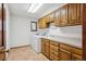 A bright laundry room with wood cabinets, tiled countertops, washer, and dryer units at 5106 S Kenton Way, Greenwood Village, CO 80111