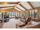 Spacious living room with wood paneling, beamed ceiling, large windows with views, and leather furniture at 5106 S Kenton Way, Greenwood Village, CO 80111