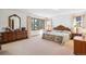 Bright main bedroom with large windows, wood furniture and comfortable carpet at 5106 S Kenton Way, Greenwood Village, CO 80111