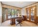 Bright office features a wooden desk, rolling chair, and large window with view at 5106 S Kenton Way, Greenwood Village, CO 80111