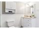 Well-lit bathroom featuring wainscotting and white cabinets providing ample storage at 775 S Alton Way # 3C, Denver, CO 80247