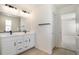 Bright bathroom with double vanity, modern fixtures, and a door leading to another room at 2237 Garden Ave, Brighton, CO 80601