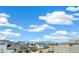 View of a vibrant neighborhood with lush green spaces under a bright blue sky with fluffy white clouds at 2237 Garden Ave, Brighton, CO 80601