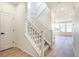 Bright entryway with a staircase featuring white railings, leading to a spacious and naturally lit upstairs area at 2237 Garden Ave, Brighton, CO 80601