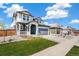 Two-story home with manicured lawn and landscaping; has two car garage, covered porch, and neutral color scheme at 2237 Garden Ave, Brighton, CO 80601