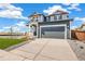 Exterior view of this two-story home featuring a two-car garage, and green landscaping at 2237 Garden Ave, Brighton, CO 80601