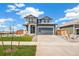 Charming two-story home with a covered porch, two-car garage, and lush green lawn at 2237 Garden Ave, Brighton, CO 80601