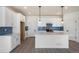 Open kitchen with white cabinets, quartz countertops, island, stainless steel appliances, and blue backsplash at 2237 Garden Ave, Brighton, CO 80601