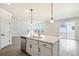 Kitchen island with quartz countertops, stainless steel dishwasher and sink with gold faucet at 2237 Garden Ave, Brighton, CO 80601