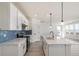 Modern kitchen with white cabinets, quartz countertops, island, and stainless steel appliances at 2237 Garden Ave, Brighton, CO 80601