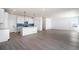 Open living space featuring wood-look floors, a modern kitchen with white cabinets, and a dining area at 2237 Garden Ave, Brighton, CO 80601