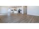 Open-concept living space featuring durable wood-look flooring and a modern kitchen with white cabinets at 2237 Garden Ave, Brighton, CO 80601