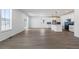 Spacious living area with wood-look floors, next to a modern kitchen with white cabinets and blue backsplash at 2237 Garden Ave, Brighton, CO 80601