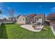 Expansive backyard with a well-kept lawn, patio, and outdoor furniture; perfect for relaxation at 11462 Iola St, Commerce City, CO 80640