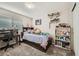 Bright bedroom featuring a wooden bed frame, study desk and chair, and a full bookshelf at 11462 Iola St, Commerce City, CO 80640