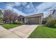 Exterior view showcasing the home's front facade, garage, driveway, and landscaped lawn at 11462 Iola St, Commerce City, CO 80640