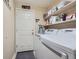 Bright laundry room features modern washer, dryer, and ample storage shelving at 11462 Iola St, Commerce City, CO 80640