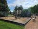 Community playground area with slide and play equipment surrounded by mature trees and blue skies at 3300 W Florida Ave # 36, Denver, CO 80219
