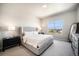 Serene bedroom with a plush upholstered bed, soft carpet, and a large window offering neighborhood views at 811 W 128Th Pl, Westminster, CO 80234