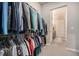 Walk-in closet with an array of hanging clothes and door to the bathroom at 811 W 128Th Pl, Westminster, CO 80234