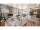 Open-concept living area with a cozy fireplace, wood floors, and seamlessly connected to the modern kitchen at 811 W 128Th Pl, Westminster, CO 80234