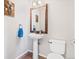 Powder room features pedestal sink, framed mirror and neutral decor at 16135 Rock Crystal Dr, Parker, CO 80134