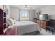 Bedroom featuring a large window with backyard view, decorative curtains, ceiling fan and television at 16135 Rock Crystal Dr, Parker, CO 80134