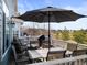 Outdoor deck area furnished with comfortable seating, dining table, and umbrella overlooking trees at 16135 Rock Crystal Dr, Parker, CO 80134