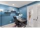 Home office with a large desk, floating shelves, and a glass door leading to the staircase at 16135 Rock Crystal Dr, Parker, CO 80134