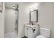 A modern bathroom features a sleek glass shower, vanity with granite countertop, and updated fixtures for a luxurious feel at 2295 S Depew St, Denver, CO 80227