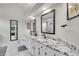 Bathroom featuring dual sinks, a granite countertop, and framed mirrors at 2295 S Depew St, Denver, CO 80227