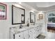 Bathroom features dual sinks, granite countertop, mirrors, and access to bedroom and walk-in closet at 2295 S Depew St, Denver, CO 80227