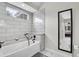 Bathroom features white tiled bathtub, window, and a large mirror at 2295 S Depew St, Denver, CO 80227