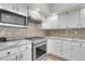 Kitchen with stainless steel appliances, white cabinets, and granite counters at 2295 S Depew St, Denver, CO 80227