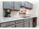 Kitchen features gray cabinets, double sink, and appliances at 3600 S Pierce St # 7-104, Denver, CO 80235